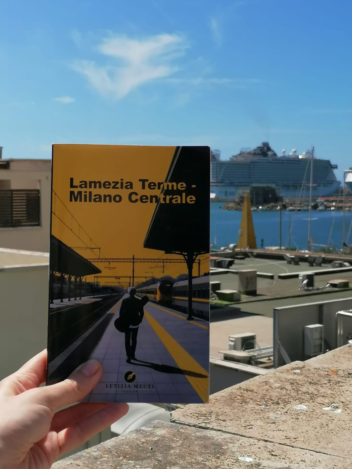 Lamezia Terme - Milano Centrale di Letizia Meuti fotografato davanti al porto e a una nave da crociera